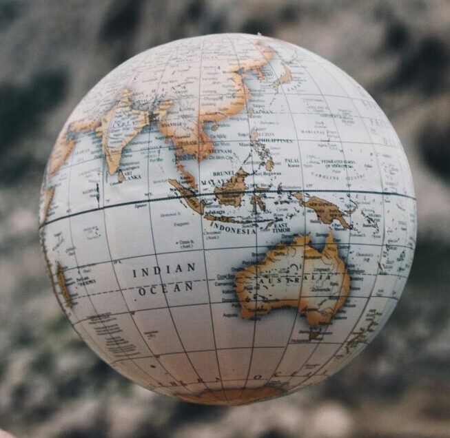 A hand holding a floating globe with a scenic Marseille backdrop, capturing adventure and exploration.